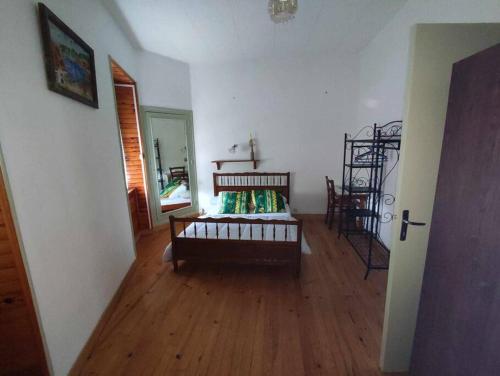a living room with a bed and a wooden floor at Le Nid Douillet Bohème Linge fourni in La Bourboule