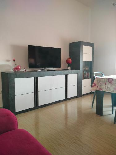 a living room with a flat screen tv on a entertainment center at B&B da Natallia in Ronco allʼAdige
