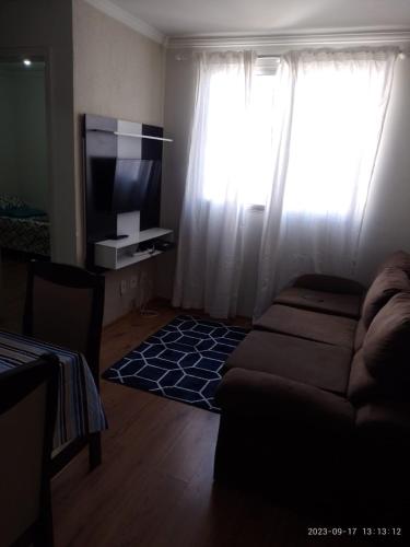 uma sala de estar com um sofá e uma televisão em Ap ótima localização em São José dos Campos