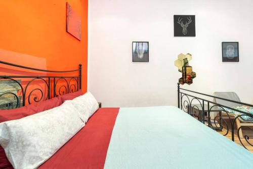 a bedroom with a red and white bed and a table at Central and cozy loft with courtyard in Bologna