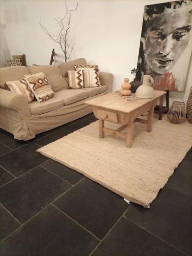a living room with a couch and a coffee table at Gite rural La Ferme du Semeur-Zaaiershof in Lessines