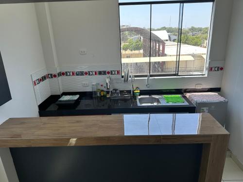 a kitchen with a counter with a sink and a window at Casa Mimaya in Piura