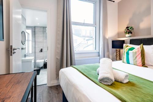 - une chambre avec un grand lit et une fenêtre dans l'établissement Fulham Studio Apartments, à Londres