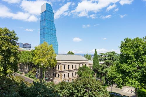 a building with a tall glass skyscraper in the background at Alma Boutique Hotel in Tbilisi City