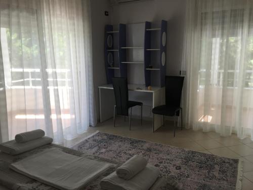 a bedroom with a bed and a desk and windows at Vacation Home in Gjiri i Lalëzit, Lalëz, Durrës in Durrës