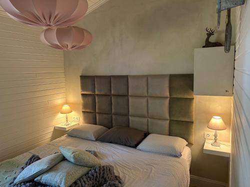 a bedroom with a large bed with two lamps at Chalet Maurice in Zutendaal