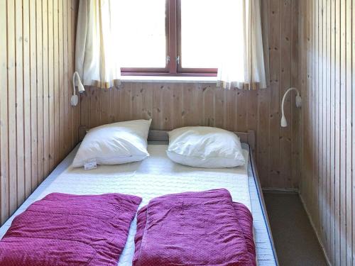 Cama en habitación con 2 almohadas y ventana en Three-Bedroom Holiday home in Dannemare 13, en Dannemare
