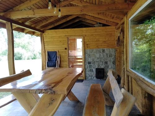 a wooden table and chairs in a cabin with a fireplace at Domek Nad Stawem in Gołdap