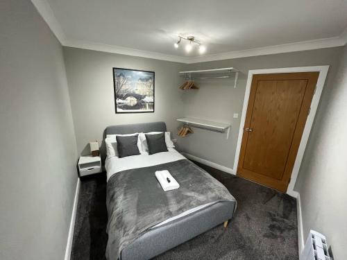 1 dormitorio con 1 cama y puerta de madera en Ultra-Luxury City centre 2 bed apartment, with FREE parking, en Cardiff
