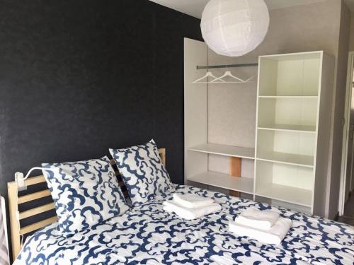 - une chambre avec un lit bleu et blanc et des oreillers dans l'établissement Lumineux / vue sur parc thermal, à Chamalières