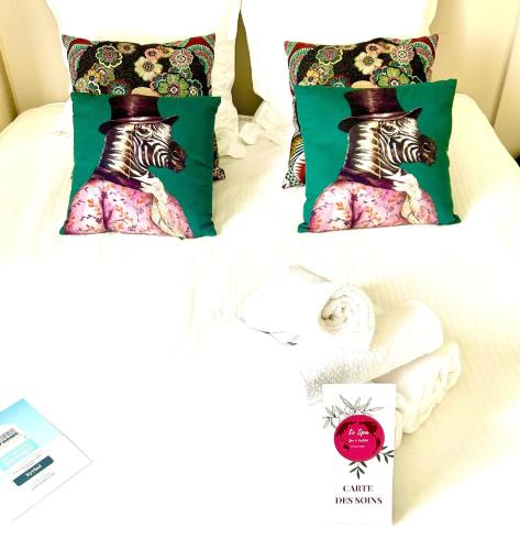 a bed with two pillows and towels on it at Kyriad Restaurant Centre SPA Vichy in Vichy