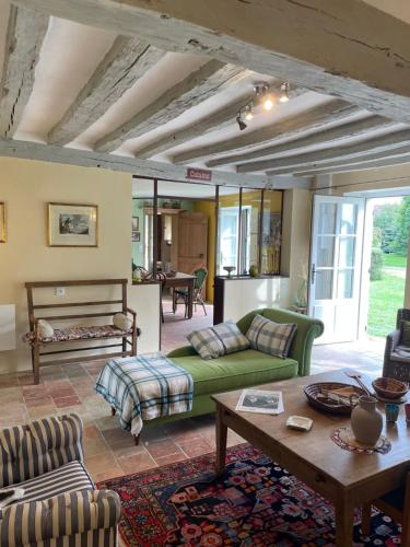 salon z zieloną kanapą i stołem w obiekcie La Chabossière w mieście Montbizot