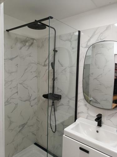 une douche avec une porte vitrée à côté d'un lavabo dans l'établissement Cosy 40m2 city center 'LE PANIER', à Marseille