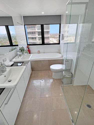 a bathroom with a tub and a toilet and a shower at Incredible ocean views 3 Bed 18th floor in Gold Coast