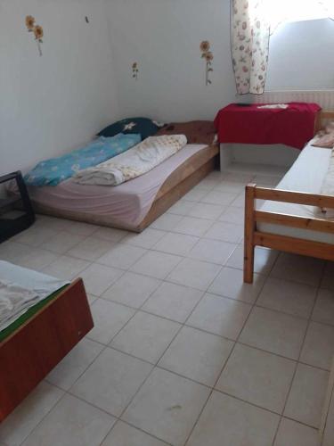 Pokój z 2 łóżkami i podłogą wyłożoną kafelkami w obiekcie Badacsonyi Panorámás magánszállás w mieście Badacsonytomaj