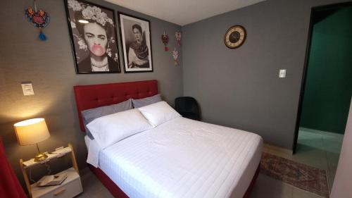 1 dormitorio con 1 cama y reloj en la pared en Departamento Nuevo a 4 minutos del Aeropuerto, en Ciudad de México
