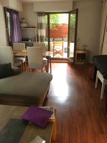 un salon avec un canapé et une table dans l'établissement Appartement COSY 3 pièces Paris 18e Montmartre Parking & Terrasses, à Paris