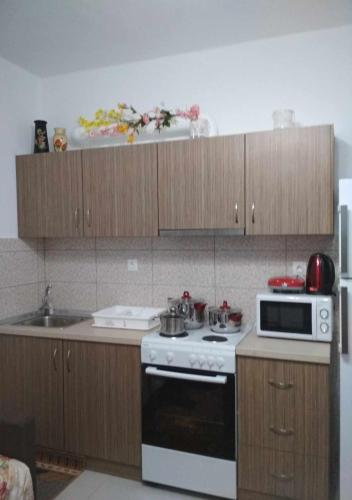 a kitchen with a white stove and wooden cabinets at Stavroula's Houses in Kélla