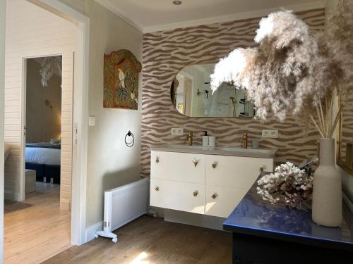 uma casa de banho com um lavatório e um espelho na parede em Chalet Maurice em Zutendaal