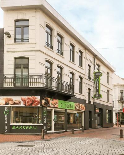 a large white building with a bakery on a street at Logies Bocadillo in Blankenberge