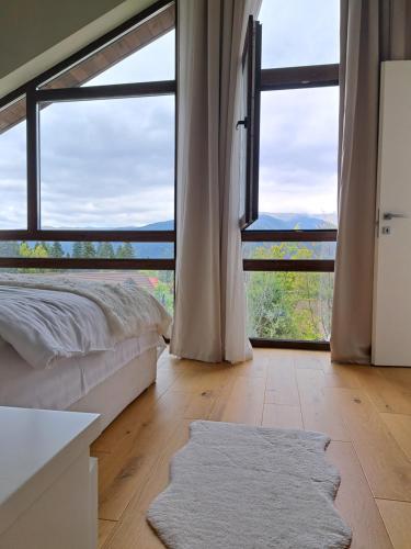 um quarto com uma cama e uma grande janela em The Rock em Sinaia