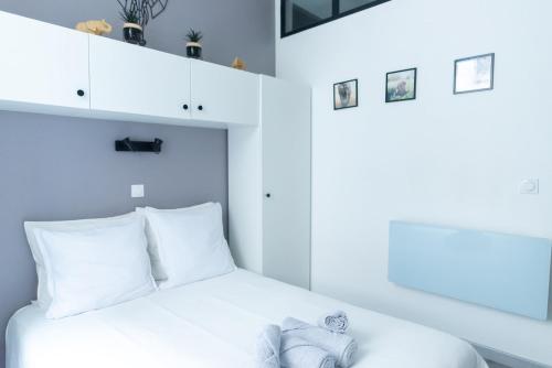 L' éléDaurat : Studio Haut Standing Riom Centre في ريوم: غرفة نوم بسرير ابيض مع مخدات بيضاء