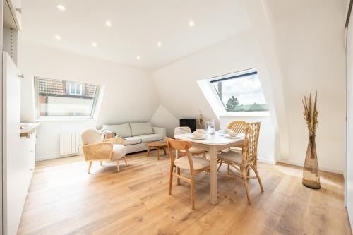un salon avec une table, des chaises et un canapé dans l'établissement Duplex Petit-Fort proche plage, à Gravelines
