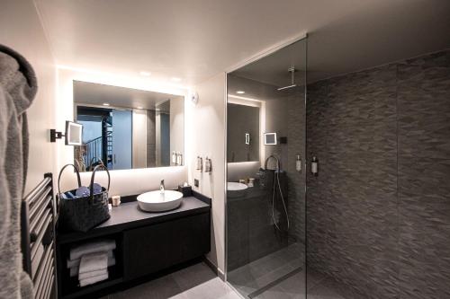 a bathroom with a sink and a glass shower at Best Western Premier Le Chapitre Hotel and Spa in Remiremont