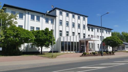 un edificio blanco al lado de una calle en Hotel Bitterfelder Hof - Mongoo GmbH, en Bitterfeld