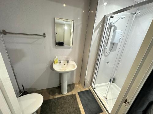 a bathroom with a shower and a sink and a toilet at Rangers GuestHouse in Glasgow