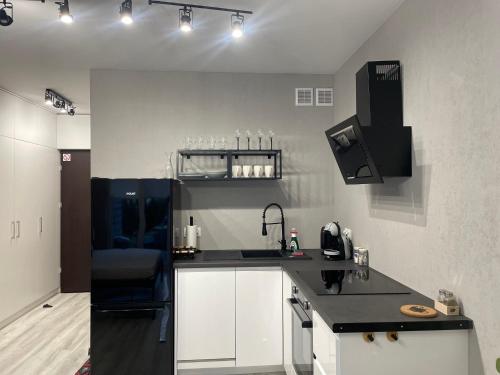 een keuken met witte kasten en een zwart aanrecht bij Apartament Poezji A39 Grey in Gliwice
