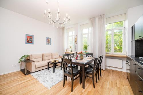 - une salle à manger et un salon avec une table et des chaises dans l'établissement Premium City Center Lukiskiu Apartment, à Vilnius