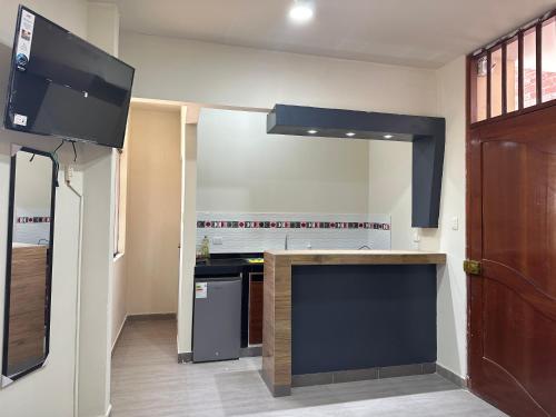 uma cozinha com um fogão e uma televisão num quarto em Casa Mimaya dpto301 em Piura