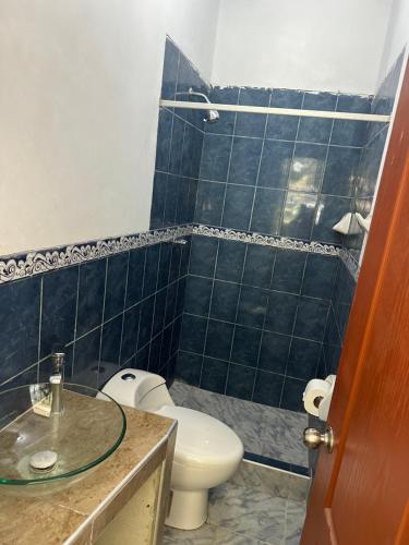 Baño de azulejos azules con aseo y lavamanos en Casa Mimaya dpto301 en Piura