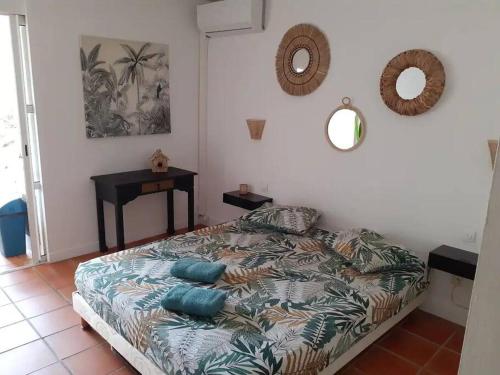 une chambre avec un lit avec des oreillers bleus et un miroir dans l'établissement Studio Coco Passion, à Saint-François