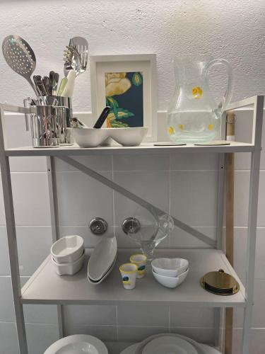 a shelf with dishes and other kitchen items on it at Sete Fontes - Agarone Holiday Nest in Agarone