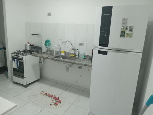 eine Küche mit einem Kühlschrank und einer Theke mit einer Spüle in der Unterkunft Apartamento condomínio Taboão da Serra/ familysnow in Taboão da Serra