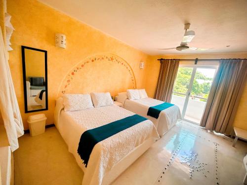 a hotel room with two beds and a window at Villa DALIJÚ in Santa Maria Huatulco