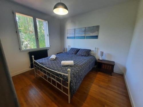 a bedroom with a bed with a blue comforter at Maison au Calme, prés du centre Parking Privé in Angoulême