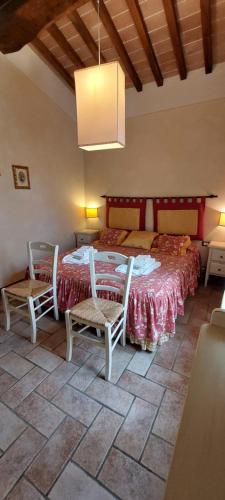 a bedroom with a bed with two chairs and a table at Agriturismo Villa Le Vigne in Montevarchi