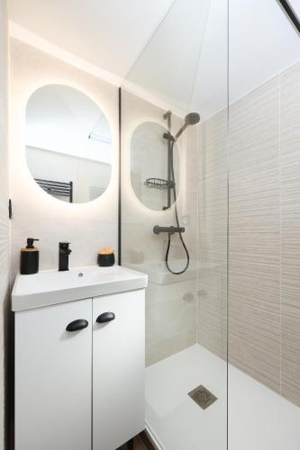 une salle de bain avec un lavabo blanc et une douche dans l'établissement Fare Laurent, à Saint Cyprien Plage