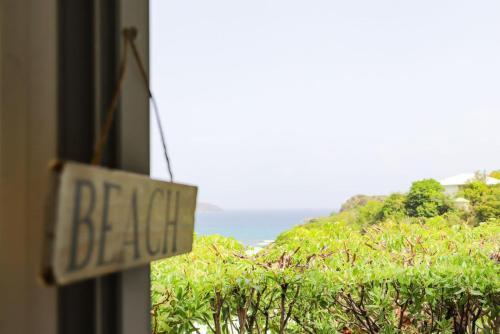 a sign that reads beta on a window with a view of the ocean at Kirsty's Place in Saint-Jean