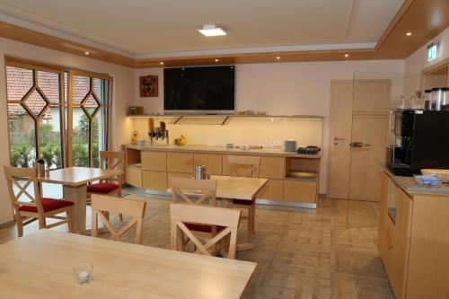 a large kitchen with a table and chairs and a counter at Leidringer Gästehaus GmbH in Rosenfeld