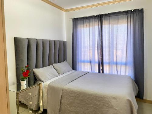 a bedroom with a large bed and a window at Siena Sun Luxury Apartment 6 in Midrand
