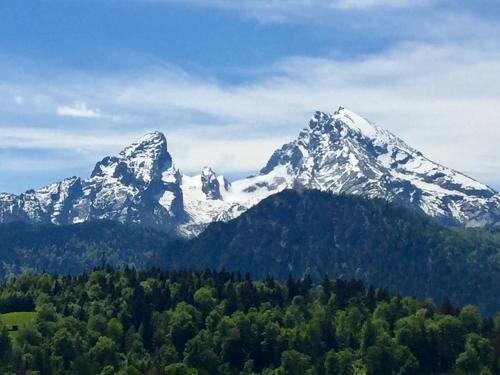 a snow capped mountain with trees in front of it at Bergbach in Ramsau