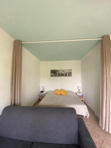 - une chambre avec un lit et des oreillers jaunes dans l'établissement Chris'Home2, à Roquebrune-Cap-Martin