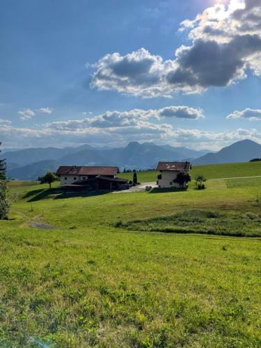 two houses in a field with mountains in the background at Ferienhaus Praschberg in Niederndorferberg