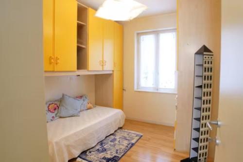 a small bedroom with yellow cabinets and a bed at Appartamento da Paola in Pescara
