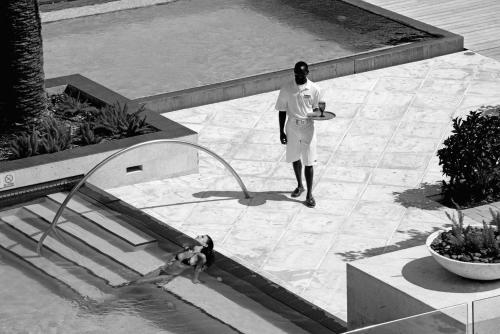 a man standing next to a dog drinking from a fountain at Grace Bay Club in Grace Bay
