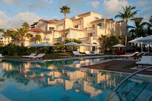a resort with a swimming pool with chairs and umbrellas at Grace Bay Club in Grace Bay